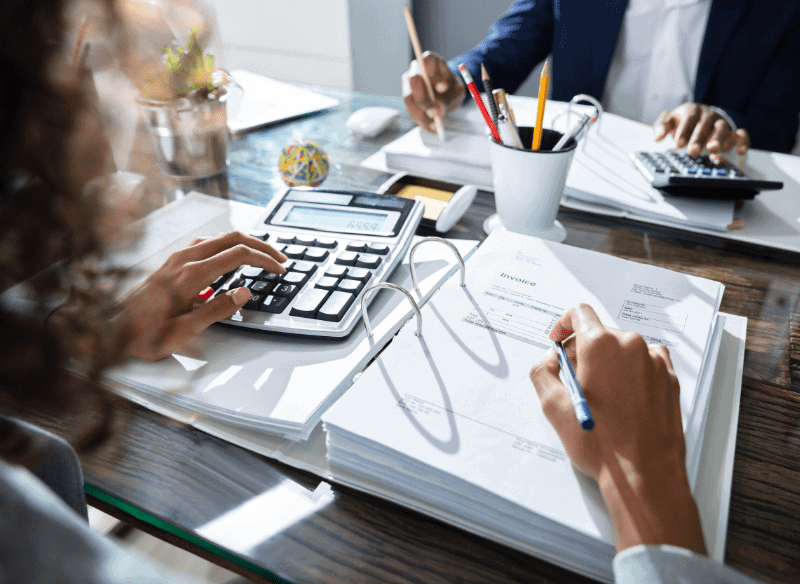 Two accountants at a desk reviewing tax documents.