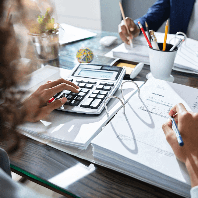 Two accountants at a desk reviewing tax documents.