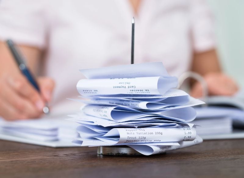 Preparation Services An accountant sitting in front of a stack of receipts.